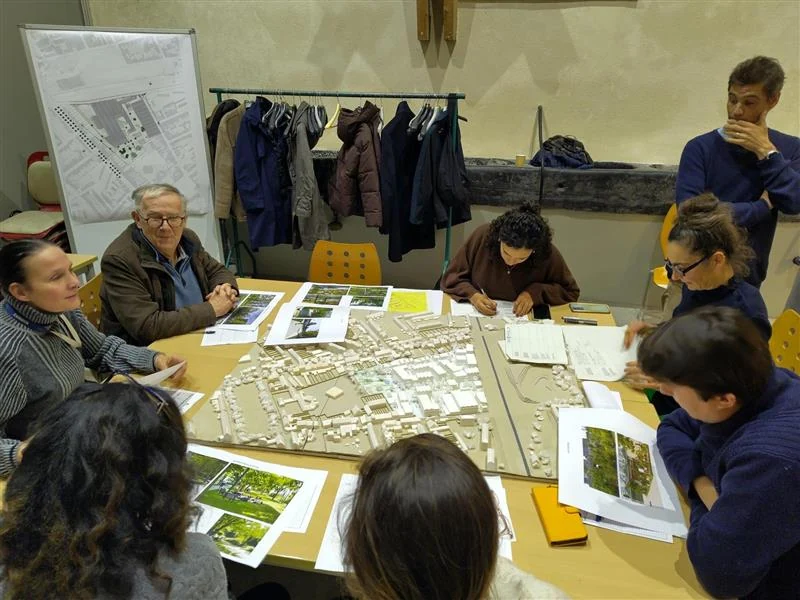 Des participants travaillent ensemble autour d’un plan et de leurs idées.