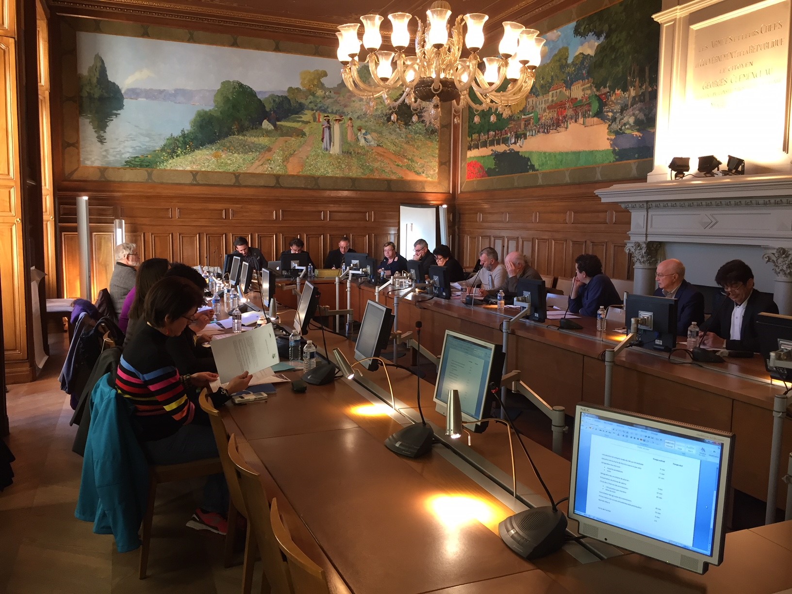 Des participants échangent autour des tables dans une salle de réunion.