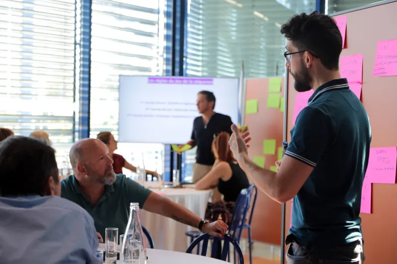 Un participant prend la parole devant un panneau de contributions pendant un atelier.
